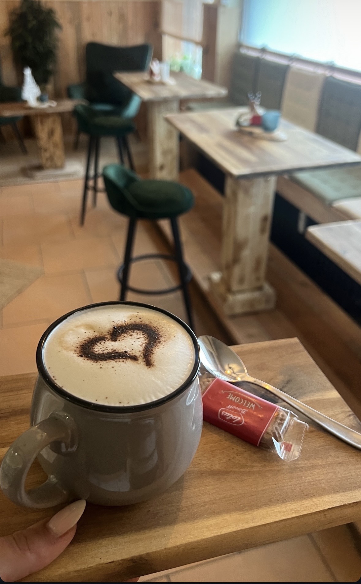 Cappuccino mit Herz aus Kakao auf einem Holztisch im Cafe Mocca